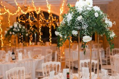 Structure en fer forgé dans un jardin, avec des invités rassemblés en arrière-plan près d'un arbre.