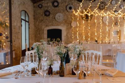 Structure en fer forgé dans un jardin, avec des invités rassemblés en arrière-plan près d'un arbre.