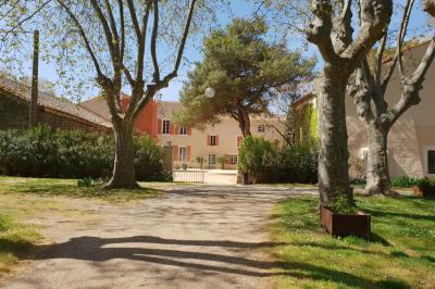 Structure en fer forgé dans un jardin, avec des invités rassemblés en arrière-plan près d'un arbre.
