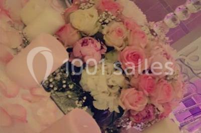 Table garnie de pâtisseries et de desserts variés, éclairée par une lumière rose et violette dans un décor festif.