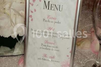 Table garnie de pâtisseries et de desserts variés, éclairée par une lumière rose et violette dans un décor festif.