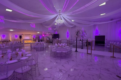 Table dressée avec des amuse-bouches variés, bougies blanches et décorations florales, en extérieur.