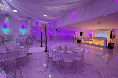 Table dressée avec des amuse-bouches variés, bougies blanches et décorations florales, en extérieur.