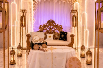 Table de réception élégamment décorée avec des fleurs blanches et rouges, bougies allumées et vaisselle raffinée.