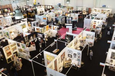 Salle circulaire avec tables rondes dressées, nappes grises et serviettes vertes, entourée de baies vitrées donnant sur des…