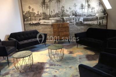 Personnes rassemblées sous une tente verte sur une terrasse, avec des plantes en pot et des clochers en arrière-plan.