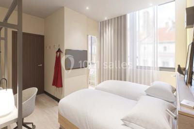 Salle de bain moderne avec murs sombres, douche à l'italienne et vue sur un sauna en bois éclairé.