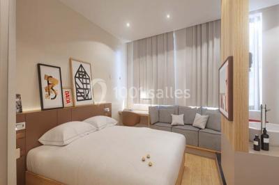 Salle de bain moderne avec murs sombres, douche à l'italienne et vue sur un sauna en bois éclairé.