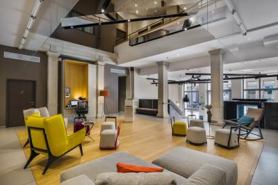 Salle de bain moderne avec murs sombres, douche à l'italienne et vue sur un sauna en bois éclairé.
