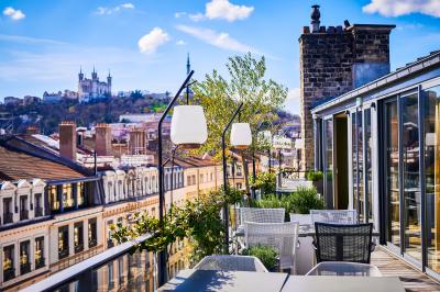 Salle de bain moderne avec murs sombres, douche à l'italienne et vue sur un sauna en bois éclairé.