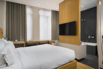 Salle de bain moderne avec murs sombres, douche à l'italienne et vue sur un sauna en bois éclairé.