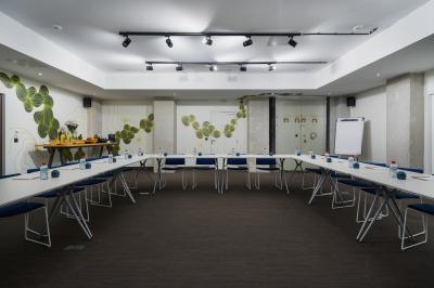 Salle de bain moderne avec murs sombres, douche à l'italienne et vue sur un sauna en bois éclairé.
