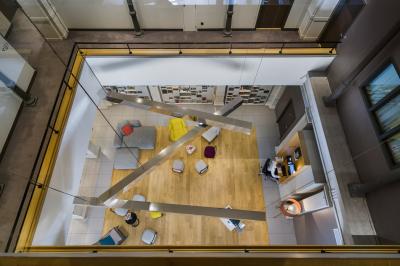 Salle de bain moderne avec murs sombres, douche à l'italienne et vue sur un sauna en bois éclairé.