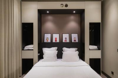 Salle de bain moderne avec murs sombres, douche à l'italienne et vue sur un sauna en bois éclairé.