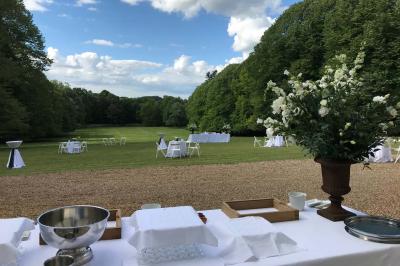 Bouquet de fleurs jaunes et blanches posé sur le capot d'une voiture ancienne noire, sous un ciel bleu.