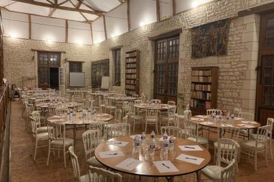 Bouquet de fleurs jaunes et blanches posé sur le capot d'une voiture ancienne noire, sous un ciel bleu.