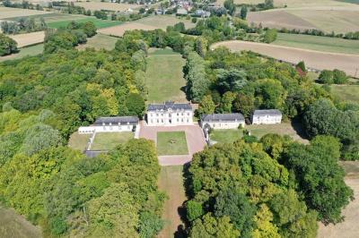 Bouquet de fleurs jaunes et blanches posé sur le capot d'une voiture ancienne noire, sous un ciel bleu.