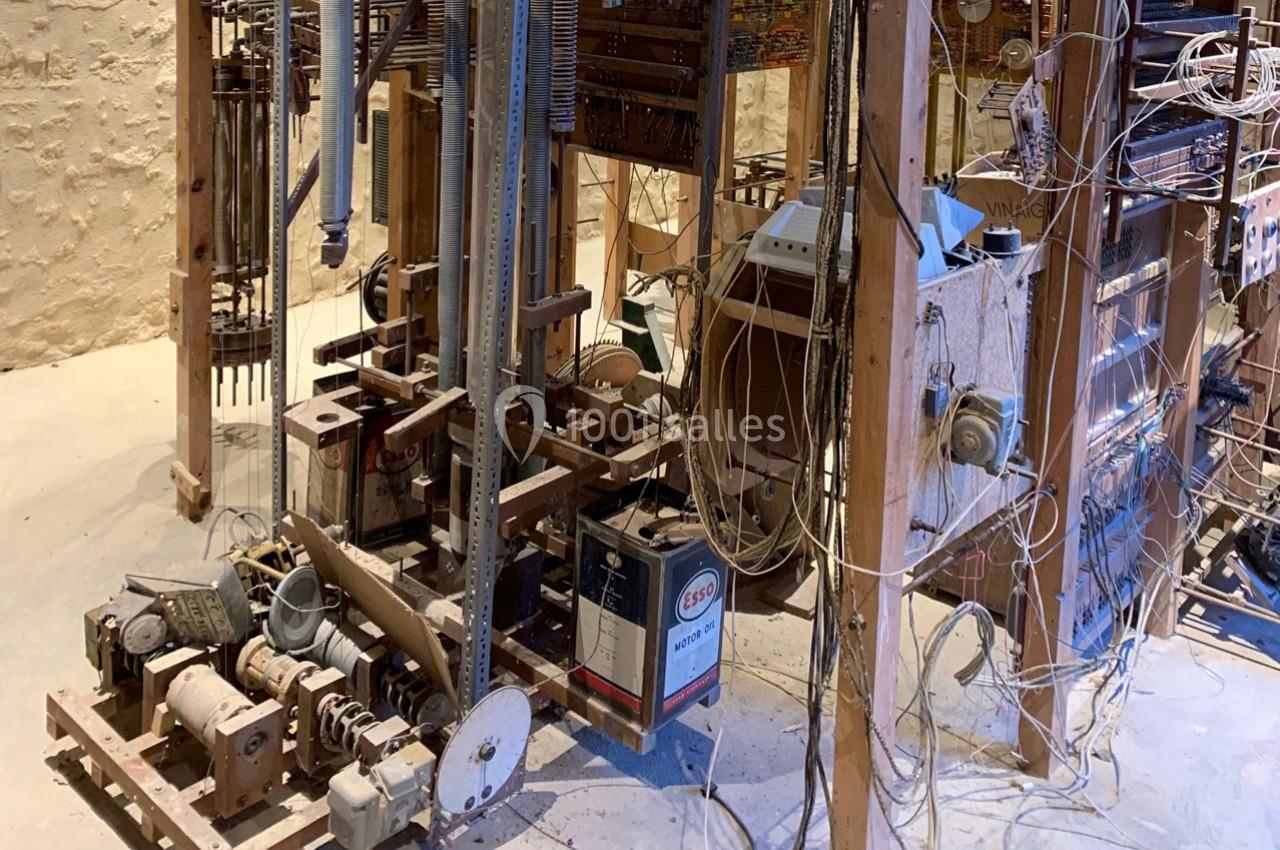 Machine artisanale complexe en bois et métal, composée de câbles, engrenages et composants électroniques.