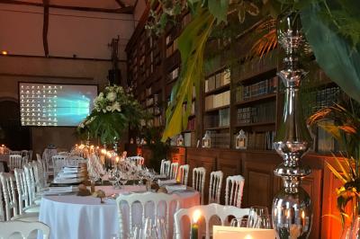 Bouquet de fleurs jaunes et blanches posé sur le capot d'une voiture ancienne noire, sous un ciel bleu.