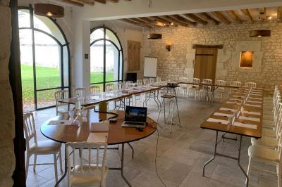 Bouquet de fleurs jaunes et blanches posé sur le capot d'une voiture ancienne noire, sous un ciel bleu.