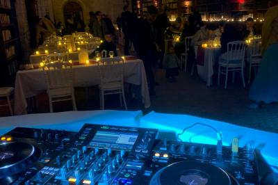 Bouquet de fleurs jaunes et blanches posé sur le capot d'une voiture ancienne noire, sous un ciel bleu.