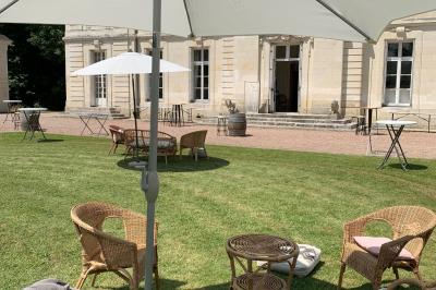 Bouquet de fleurs jaunes et blanches posé sur le capot d'une voiture ancienne noire, sous un ciel bleu.