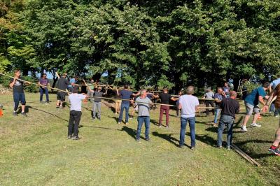 Bouquet de fleurs jaunes et blanches posé sur le capot d'une voiture ancienne noire, sous un ciel bleu.