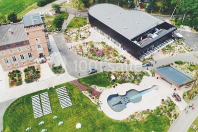 Salle de bain lumineuse avec lavabo sur meuble en bois, miroir mural, rideau jaune et fenêtre donnant sur l'extérieur.