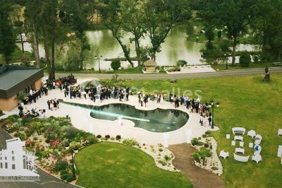 Salle de bain lumineuse avec lavabo sur meuble en bois, miroir mural, rideau jaune et fenêtre donnant sur l'extérieur.