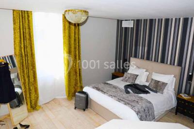 Salle de bain lumineuse avec lavabo sur meuble en bois, miroir mural, rideau jaune et fenêtre donnant sur l'extérieur.