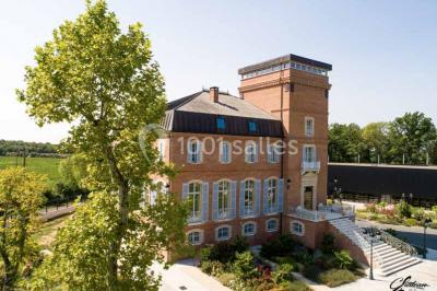 Salle de bain lumineuse avec lavabo sur meuble en bois, miroir mural, rideau jaune et fenêtre donnant sur l'extérieur.