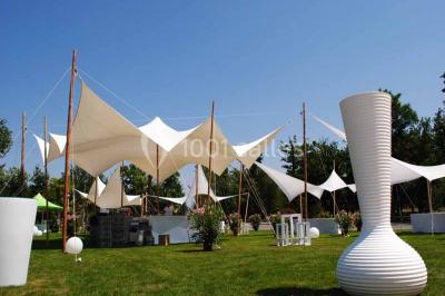 Salle de bain lumineuse avec lavabo sur meuble en bois, miroir mural, rideau jaune et fenêtre donnant sur l'extérieur.