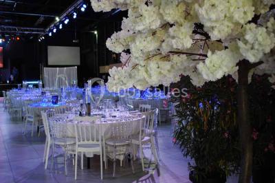 Salle de bain lumineuse avec lavabo sur meuble en bois, miroir mural, rideau jaune et fenêtre donnant sur l'extérieur.
