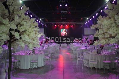 Salle de bain lumineuse avec lavabo sur meuble en bois, miroir mural, rideau jaune et fenêtre donnant sur l'extérieur.