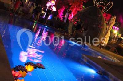 Salle de bain lumineuse avec lavabo sur meuble en bois, miroir mural, rideau jaune et fenêtre donnant sur l'extérieur.