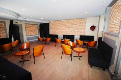 Maison moderne à deux étages avec façade en bois, terrasse et jardinières fleuries sur une allée pavée.