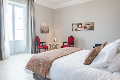 Maison moderne à deux étages avec façade en bois, terrasse et jardinières fleuries sur une allée pavée.