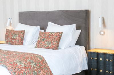 Maison moderne à deux étages avec façade en bois, terrasse et jardinières fleuries sur une allée pavée.