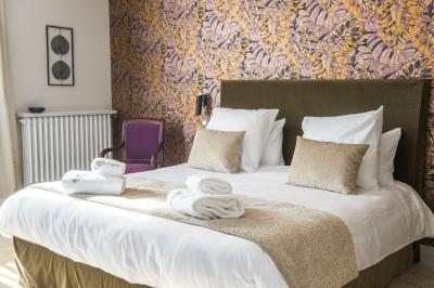 Maison moderne à deux étages avec façade en bois, terrasse et jardinières fleuries sur une allée pavée.