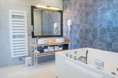 Maison moderne à deux étages avec façade en bois, terrasse et jardinières fleuries sur une allée pavée.