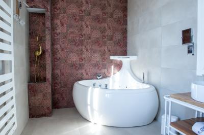 Maison moderne à deux étages avec façade en bois, terrasse et jardinières fleuries sur une allée pavée.