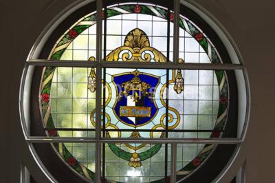 Salle de réception lumineuse avec tables hautes, décor floral et éclairage coloré.
