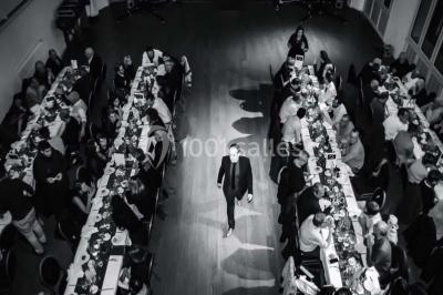 Salle de réception lumineuse avec tables hautes, décor floral et éclairage coloré.