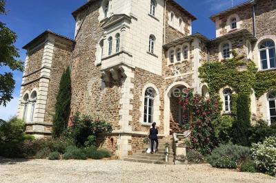 Table en bois dressée avec vaisselle, verres, fruits et fleurs, dans une salle lumineuse au décor chaleureux.
