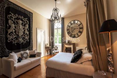 Table en bois dressée avec vaisselle, verres, fruits et fleurs, dans une salle lumineuse au décor chaleureux.