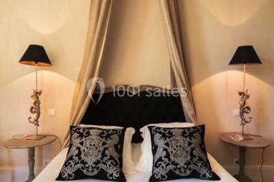 Table en bois dressée avec vaisselle, verres, fruits et fleurs, dans une salle lumineuse au décor chaleureux.
