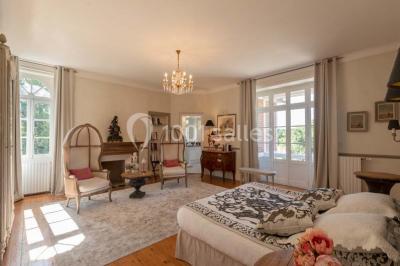 Table en bois dressée avec vaisselle, verres, fruits et fleurs, dans une salle lumineuse au décor chaleureux.