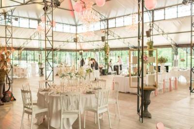 Table en bois dressée avec vaisselle, verres, fruits et fleurs, dans une salle lumineuse au décor chaleureux.