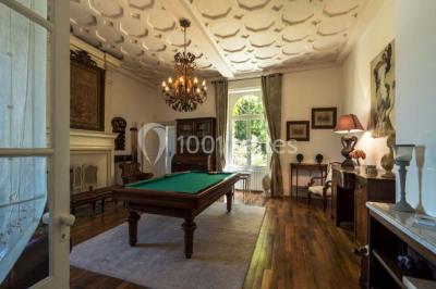 Table en bois dressée avec vaisselle, verres, fruits et fleurs, dans une salle lumineuse au décor chaleureux.
