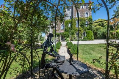 Table en bois dressée avec vaisselle, verres, fruits et fleurs, dans une salle lumineuse au décor chaleureux.